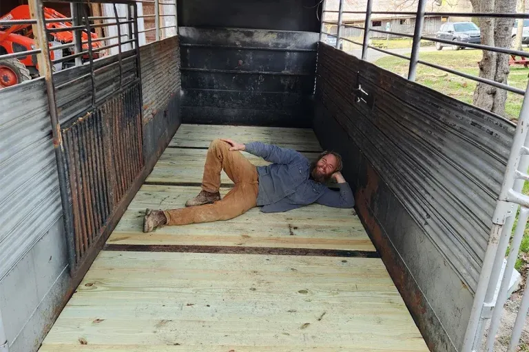 农民格雷格躺在牲畜拖车的木地板上